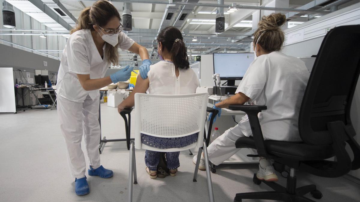 Una niña recibe la primera dosis de la vacuna Pfizer en el Hospital Zendal de Madrid.