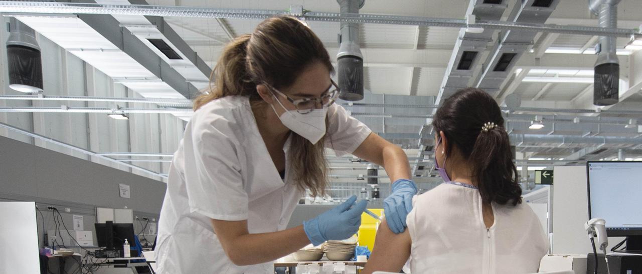 Una joven recibe la primera dosis de la vacuna Pfizer en el Hospital Zendal.