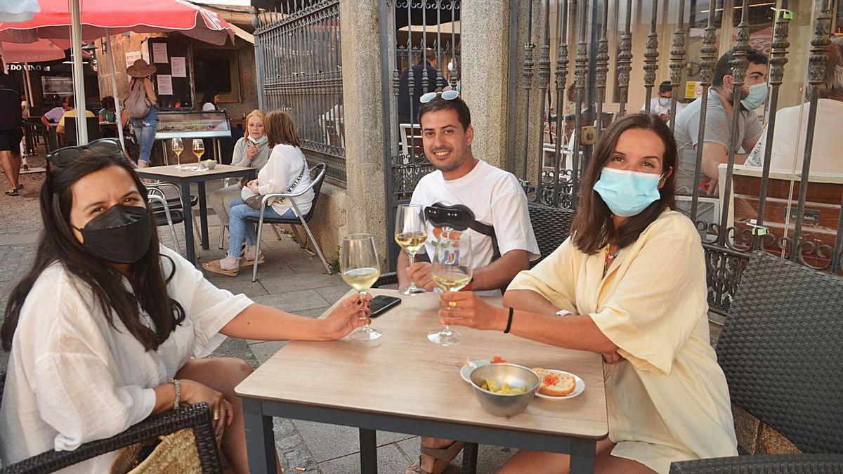 Tres jóvenes brindan con albariño en una terraza de Cambados. |   // NOÉ PARGA