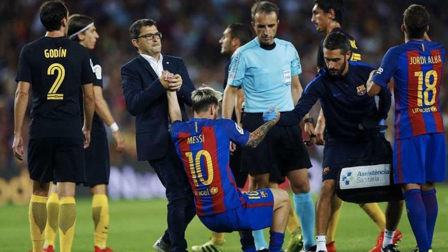 Messi necesitó ayuda para levantarse tras sufrir una lesión muscular el miércoles. // Alejandro García