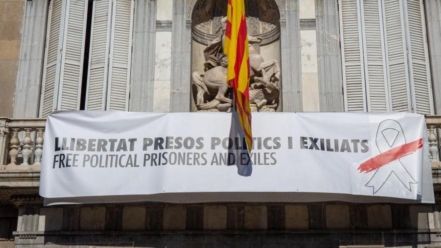 Balcón del edificio de la Generalitat con pancarta con lazo blanco.