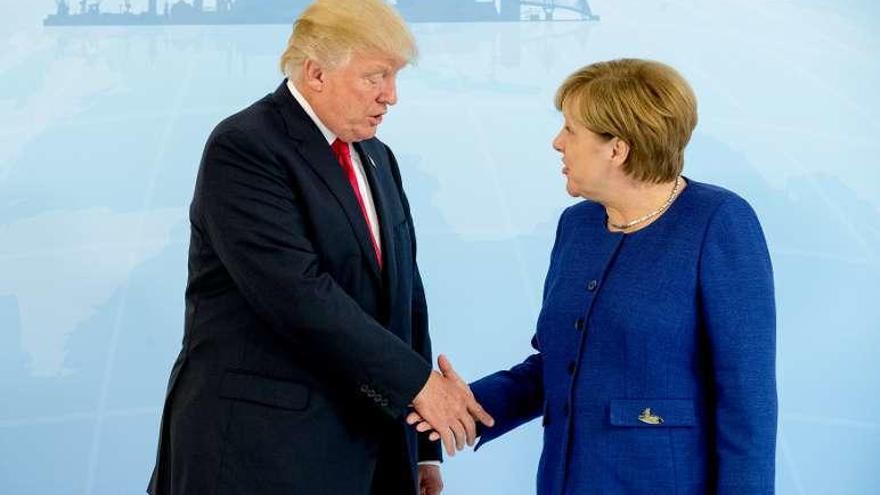 Trump y Merkel se saludan en Hamburgo la víspera del G-20. // Reuters