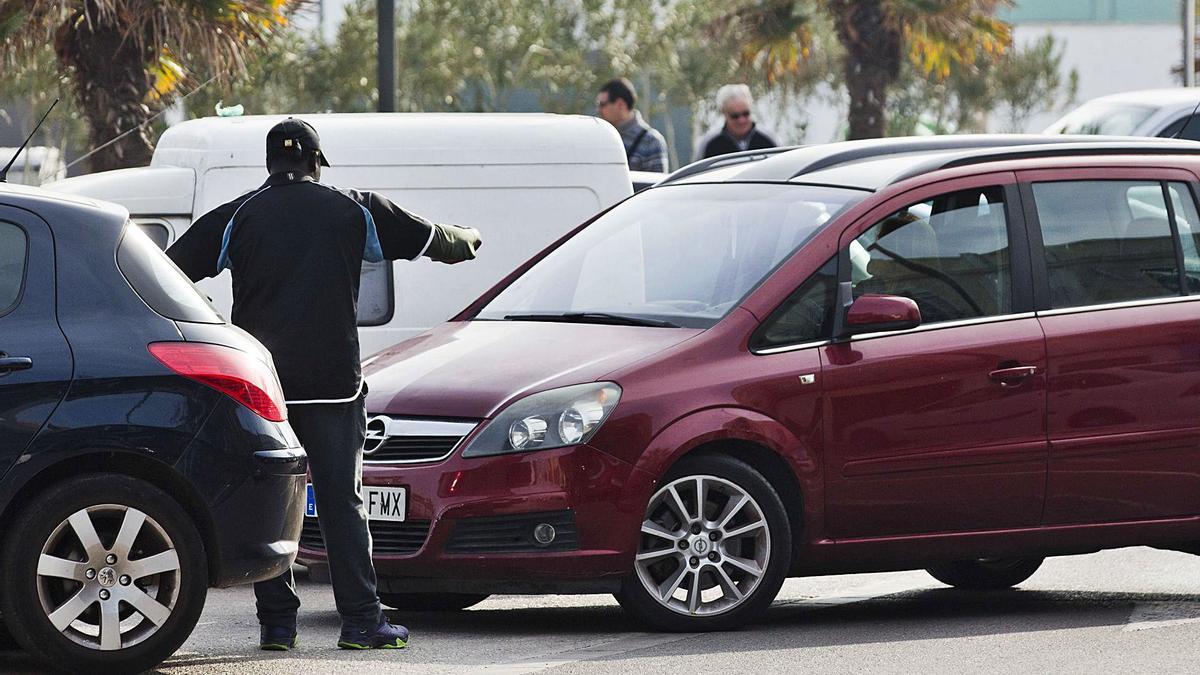 Un gorrilla ayuda a aparcar un coche en una calle de València, en una imagen de archivo. | LEVANTE-EMV