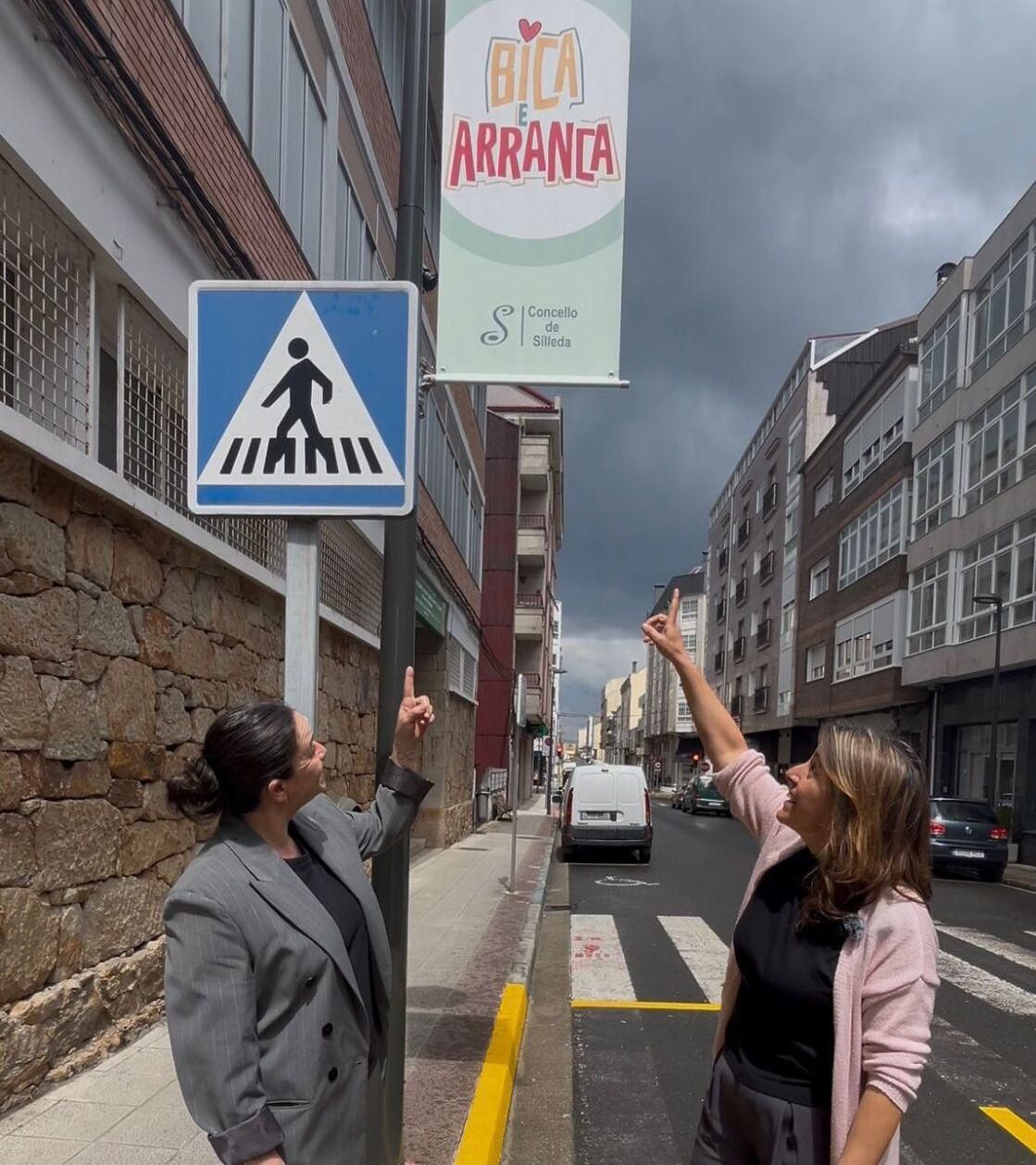 Paula Fernández Pena y Ángela Troitiño, junto a una señal de Bica e Arranca.