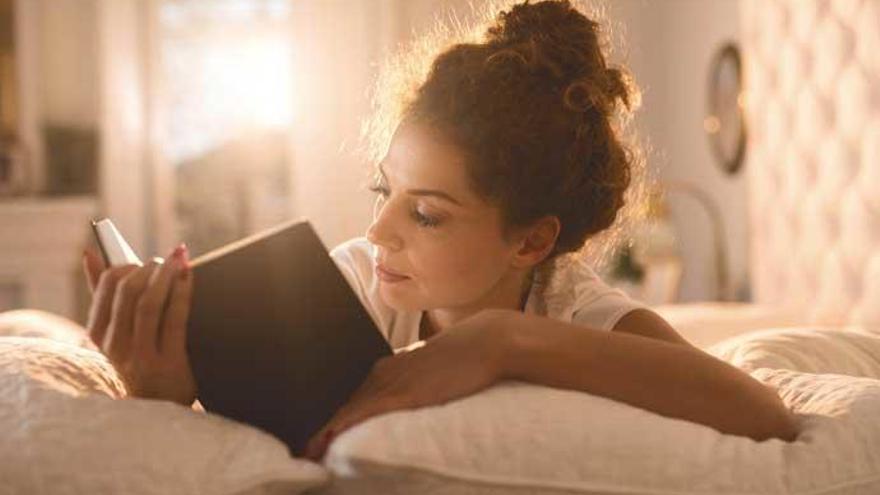 Una mujer inmersa en la lectura de un libro.