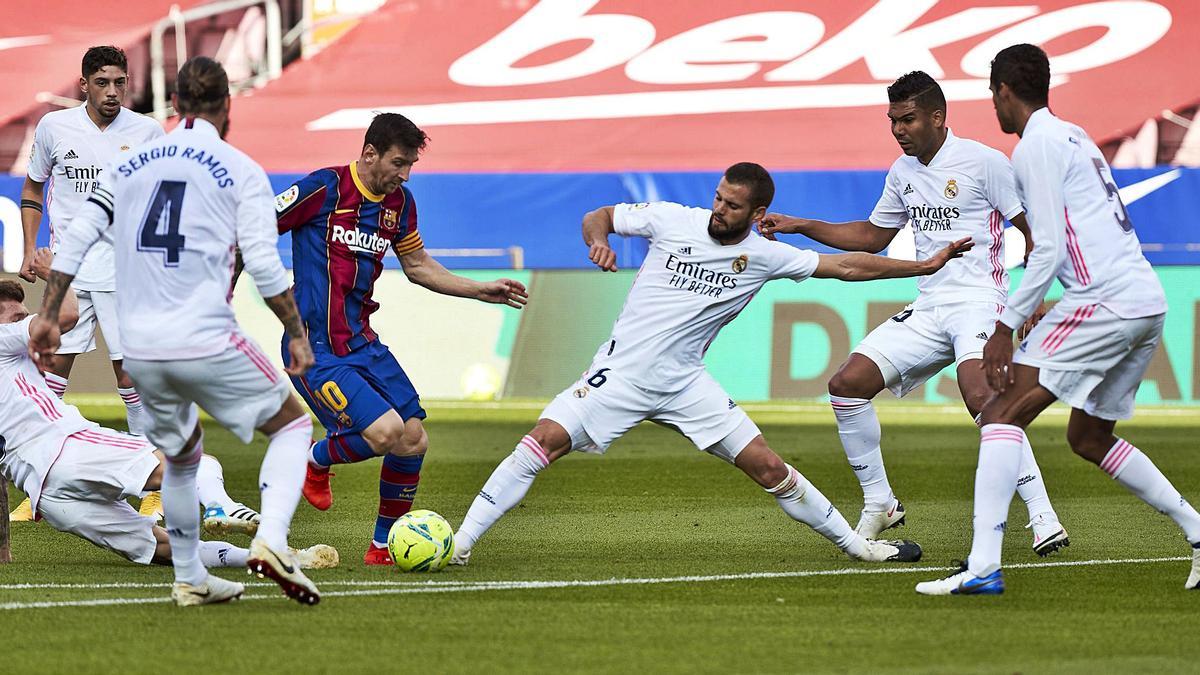 Messi, presionado por seis jugadores del Real Madrid, ayer en el Camp Nou, en un clásico sin público en el que los blancos traspasaron su crisis al Barcelona.