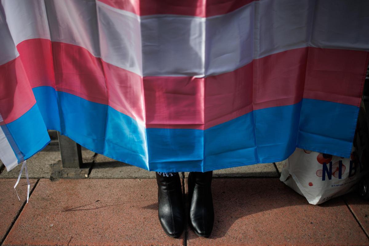 Una persona porta la bandera trans