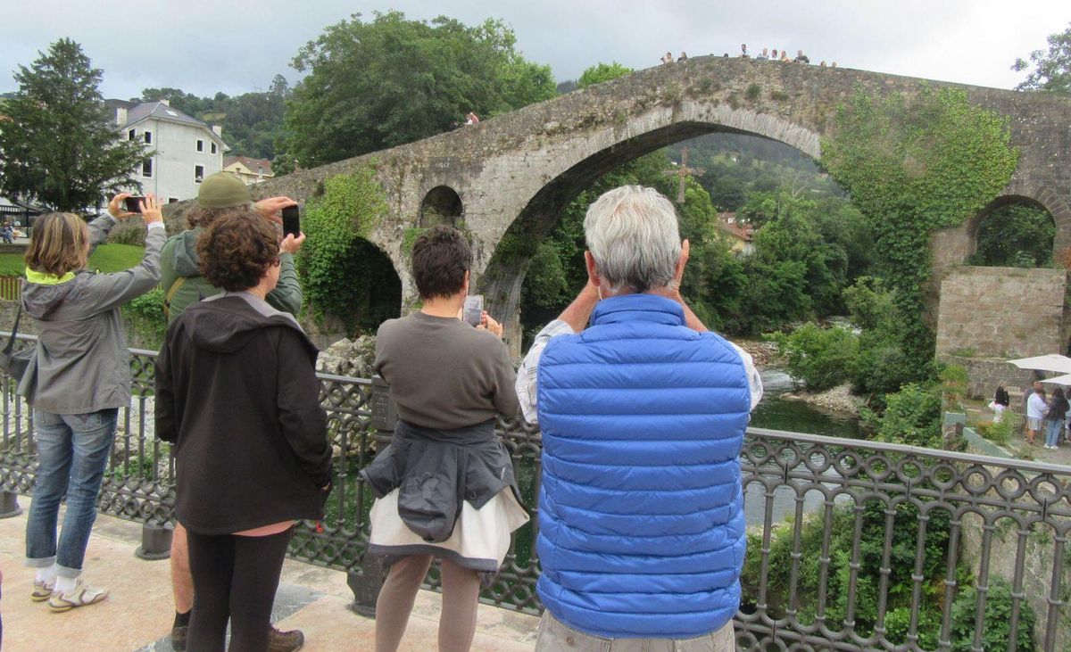 Un grupo de turistas fotografía el puente «romano» de Cangas de Onís. | J. M. CARBAJAL
