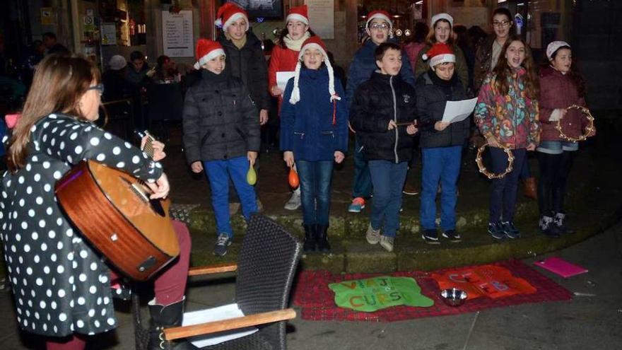 Un grupo de jóvenes despide el año cantando villancicos en la plaza de A Ferrería. // Rafa Vázquez