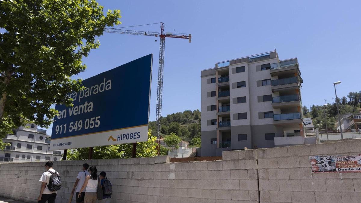 Un grupo de jóvenes pasea frente al proyecto de obra inacabada que se comercializa en la Avenida Pintor Juan Francés de Xàtiva.