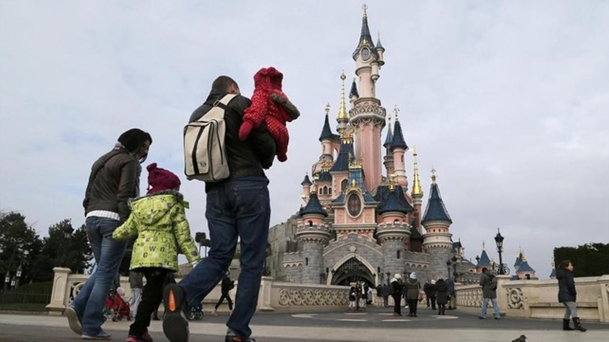 Una familia de visitantes se dirige hacia el castillo encantado durante su visita a Disneyland París, el 21 de enero.