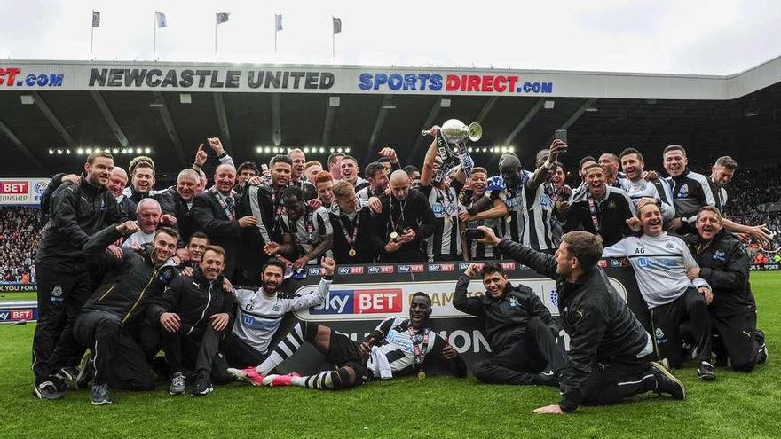 Cristian Fernández, a la izquierda, tumbado sobre el césped puño en alto, en la celebración del título de liga con el Newcastle. // FdV