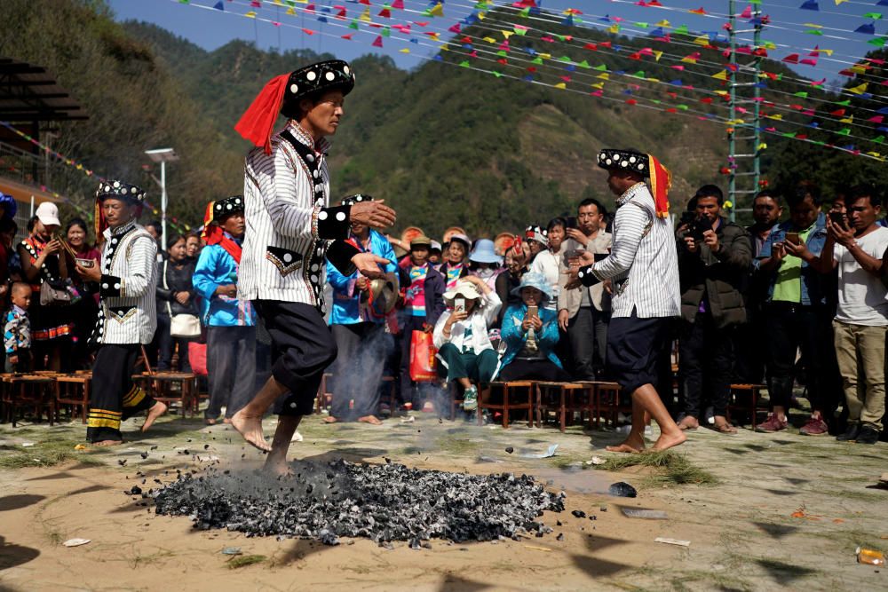 An ethnic Lisu man dances barefoot on hot ...