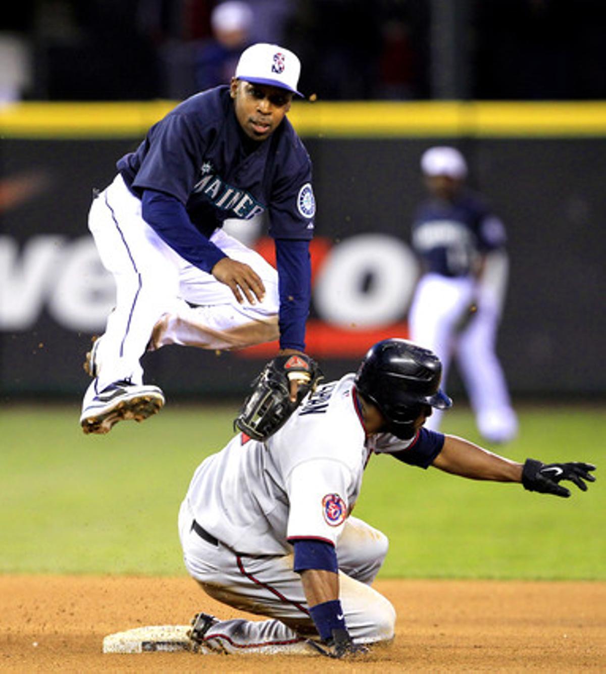 El segona base de l’equip de beisbol Seattle Mariners Chone Figgins salta sobre Denar Span, del Minessota Twins durant la vuitena entrada del partit.