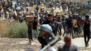 Palestinos tras una entrega de ayuda de la Fundación Humanitaria de Gaza, respaldada por Israel y Estados Unidos, en el sur de la Franja (archivo)