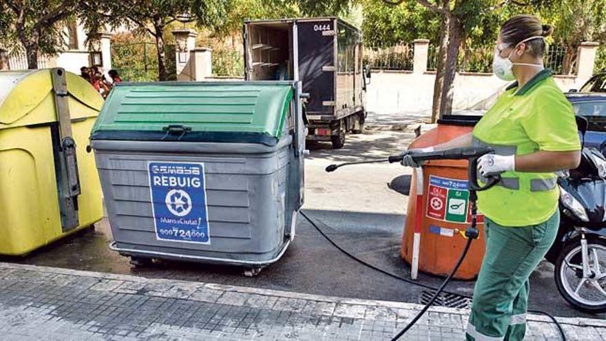 Un operario de Emaya limpia un contenedor de basura.