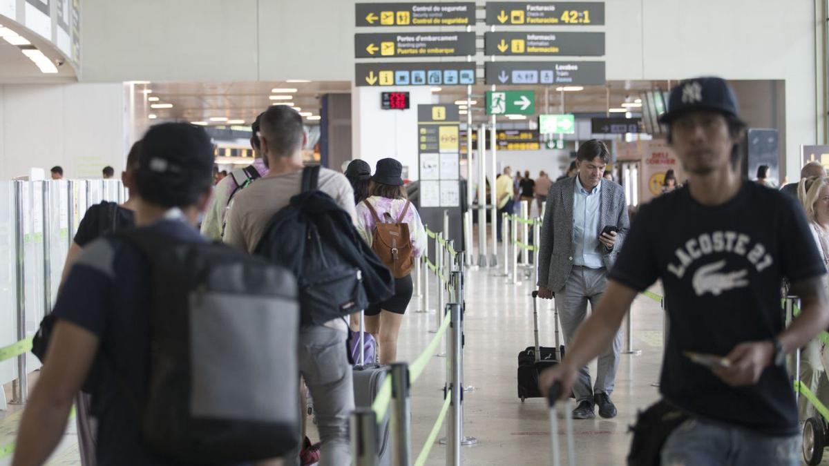 Varios turistas en el aeropuerto de Manises, la pasada semana, antes de embarcar. | F.BUSTAMANTE