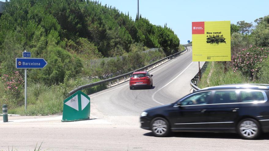 La rotonda a l&#039;entrada de Blanes amb un vehicle pujant la rampa per accedir a la C-32 |