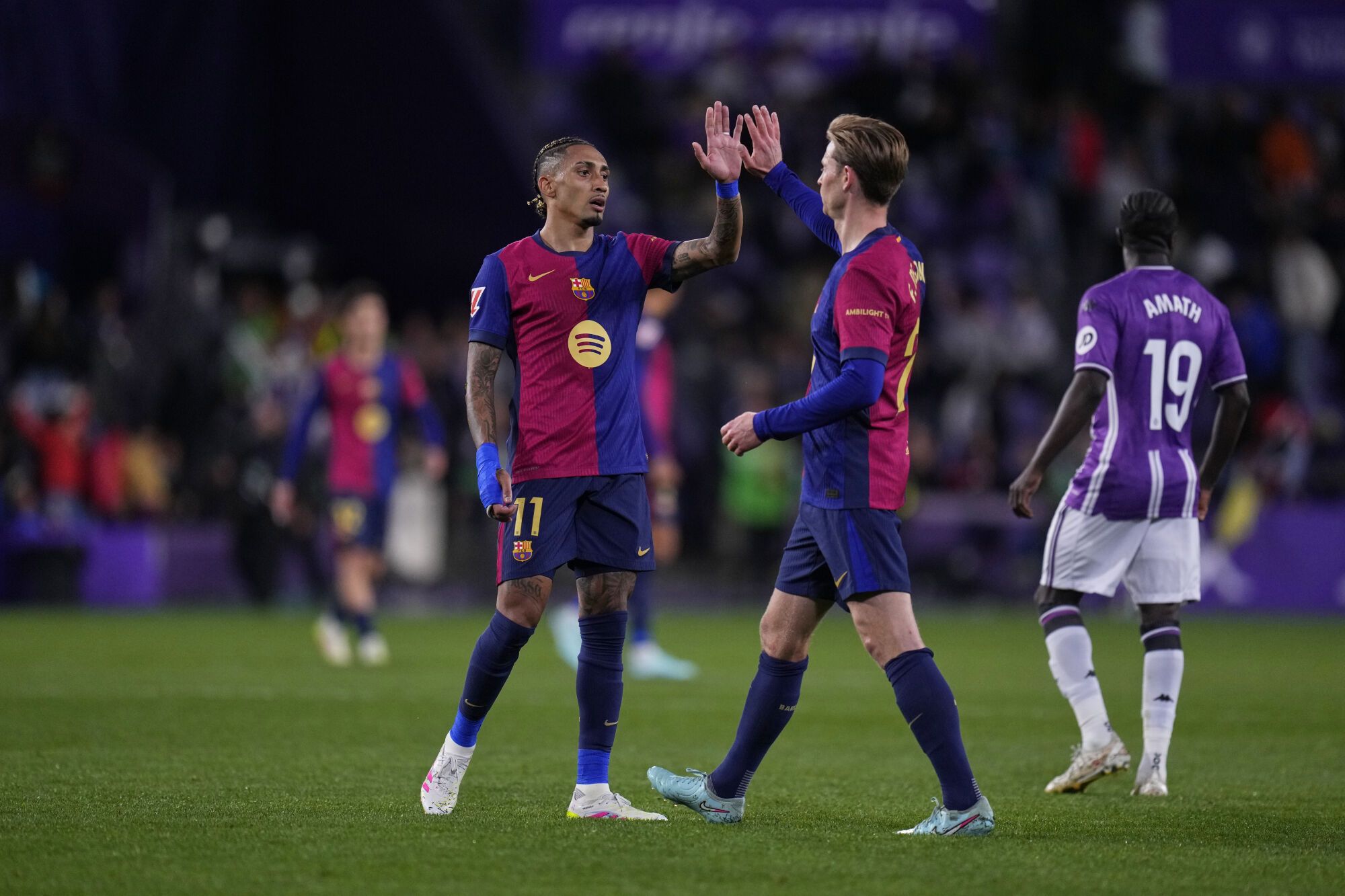 Barcelona's Raphinha, left, and Barcelona's Frenkie de Jong celebrate after the Spanish La Liga soccer match between Valladolid and FC Barcelona at the Jose Zorrilla stadium in Valladolid, Spain, Saturday, May 3, 2025. (AP Photo/Manu Fernandez)