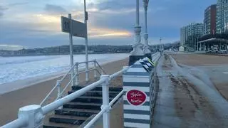 Los efectos del oleaje en Gijón: el paseo del Muro se llena de arena