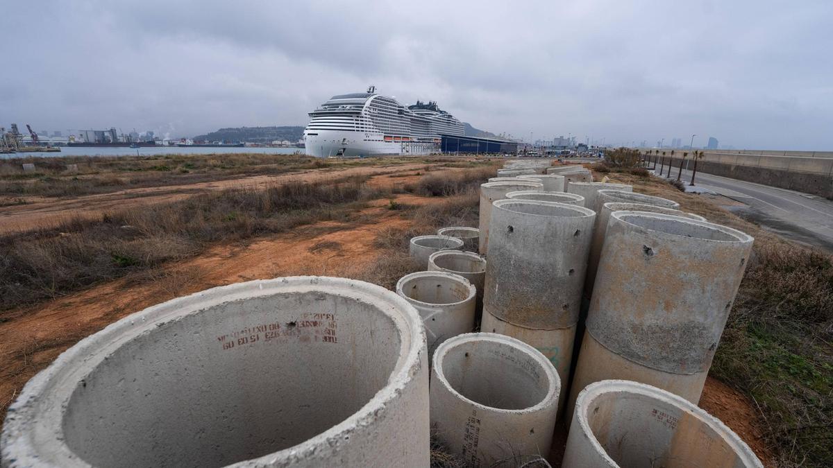 Varios tubos para canalizaciones de obras en el Moll Adossat del Port de Barcelona, con un crucero de MSC atracado en la terminal H.