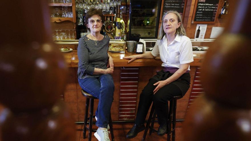 Marta Pérez, a la izquierda, con su hermana Isabel, en la barra de su restaurante de la calle Campomanes. | LUISMA MURIAS