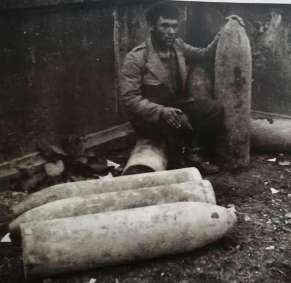 Un soldado nacional posa junto a algunas de las bombas lanzadas por los alemanes que no llegaron a explotar.