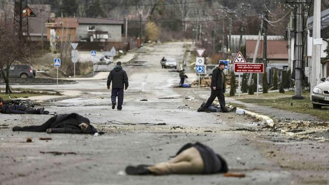 Bodies lie on a street in Bucha, northwest of Kyiv, as Ukraine says Russian forces are making a "rapid retreat" from northern areas around Kyiv and the city of Chernigiv, on April 2, 2022. - The bodies of at least 20 men in civilian clothes were found lying in a single street Saturday after Ukrainian forces retook the town of Bucha near Kyiv from Russian troops, AFP journalists said. Russian forces withdrew from several towns near Kyiv in recent days after Moscow's bid to encircle the capital failed, with Ukraine declaring that Bucha had been "liberated". (Photo by RONALDO SCHEMIDT / AFP)