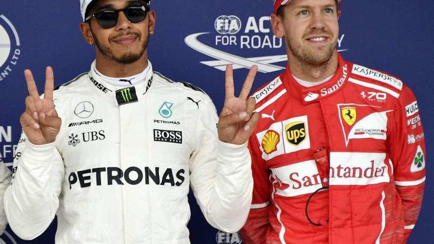 Hamilton hace el símbolo de la victoria junto a Vettel tras la calificación de ayer en Japón.