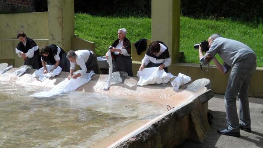 A la izquierda, Alejandro Braña retrata a las integrantes del grupo «Les Ayalgues» en la fuente de Santarúa, en Candás; a la derecha, mujeres lavando en el río Rita.