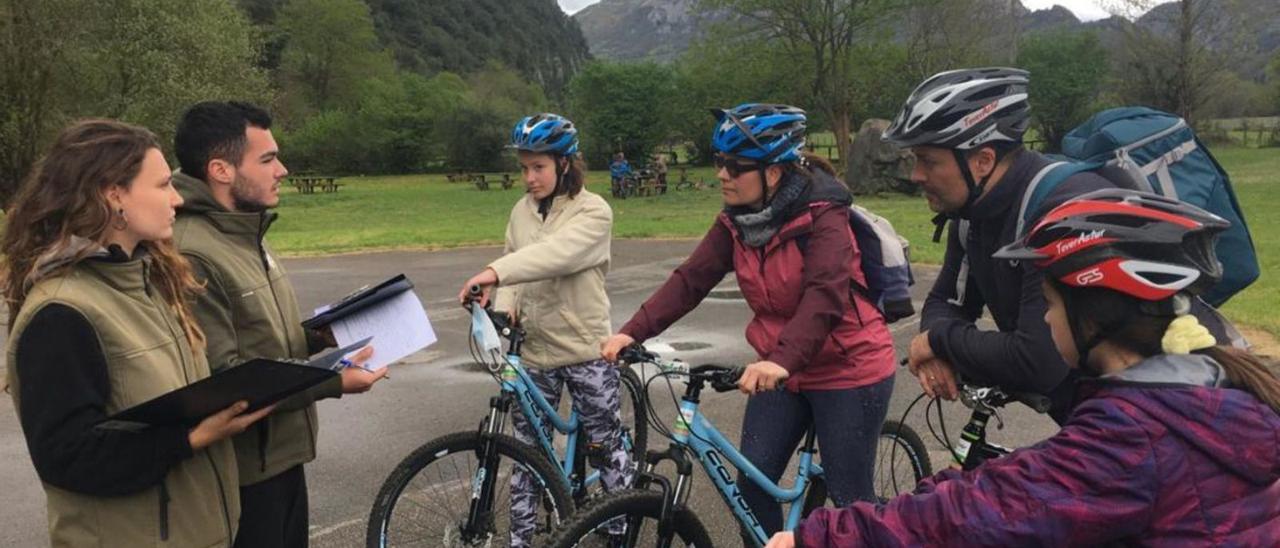 Los informadores ambientales de FOA Lucía Cerra y Nacho Cabildo, ayer, en Proaza, asesorando a Amara Pardo Ares, Paula Ares Otero, Carlos Alberto Pardo García y Martina Pardo Ares, de Galicia. | S. Arias