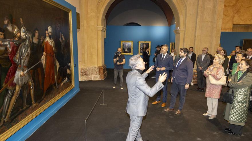 Durante la inauguración, el comisario Nacho Ruiz, muestra la pintura ‘Episodio de la conquista de Málaga (Moro Santo)’. | E. S.