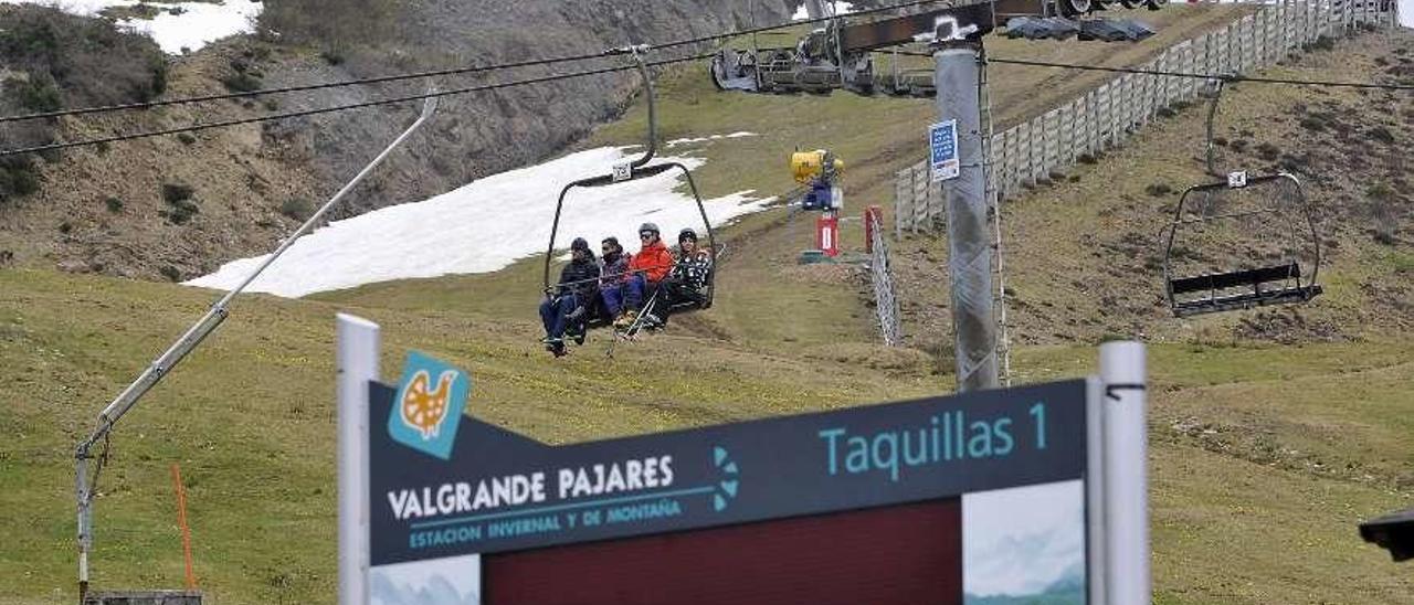 Usuarios en uno de los telesillas de Pajares, sin apenas nieve alrededor.