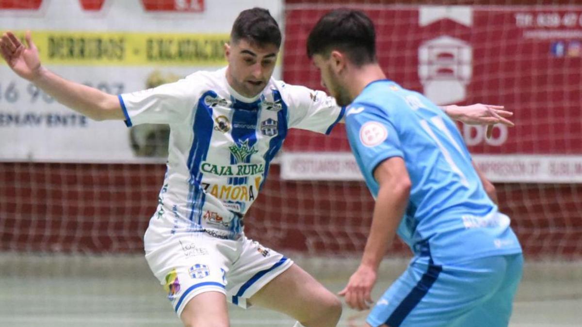 Un jugador del Atlético Benavente trata de frenar a un adversario.