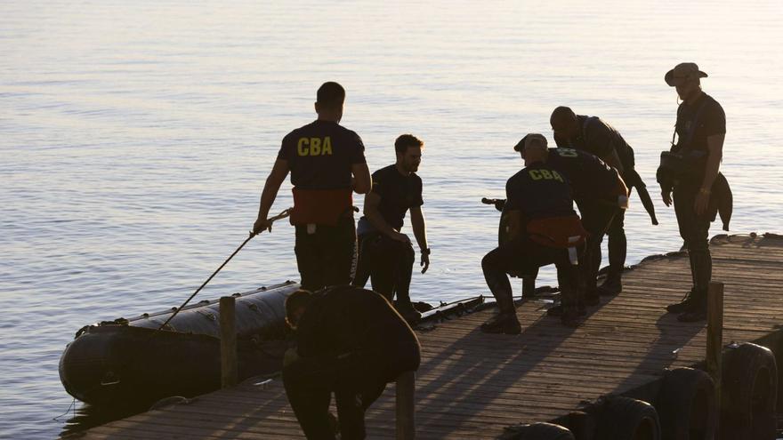 Buzos de la Armada recogen su neumática tras una jornada más de búsqueda de cuerpos en l’Albufera. A la derecha, agentes del Greim de la Guardia Civil buscan entre las cañas, en el lago. |