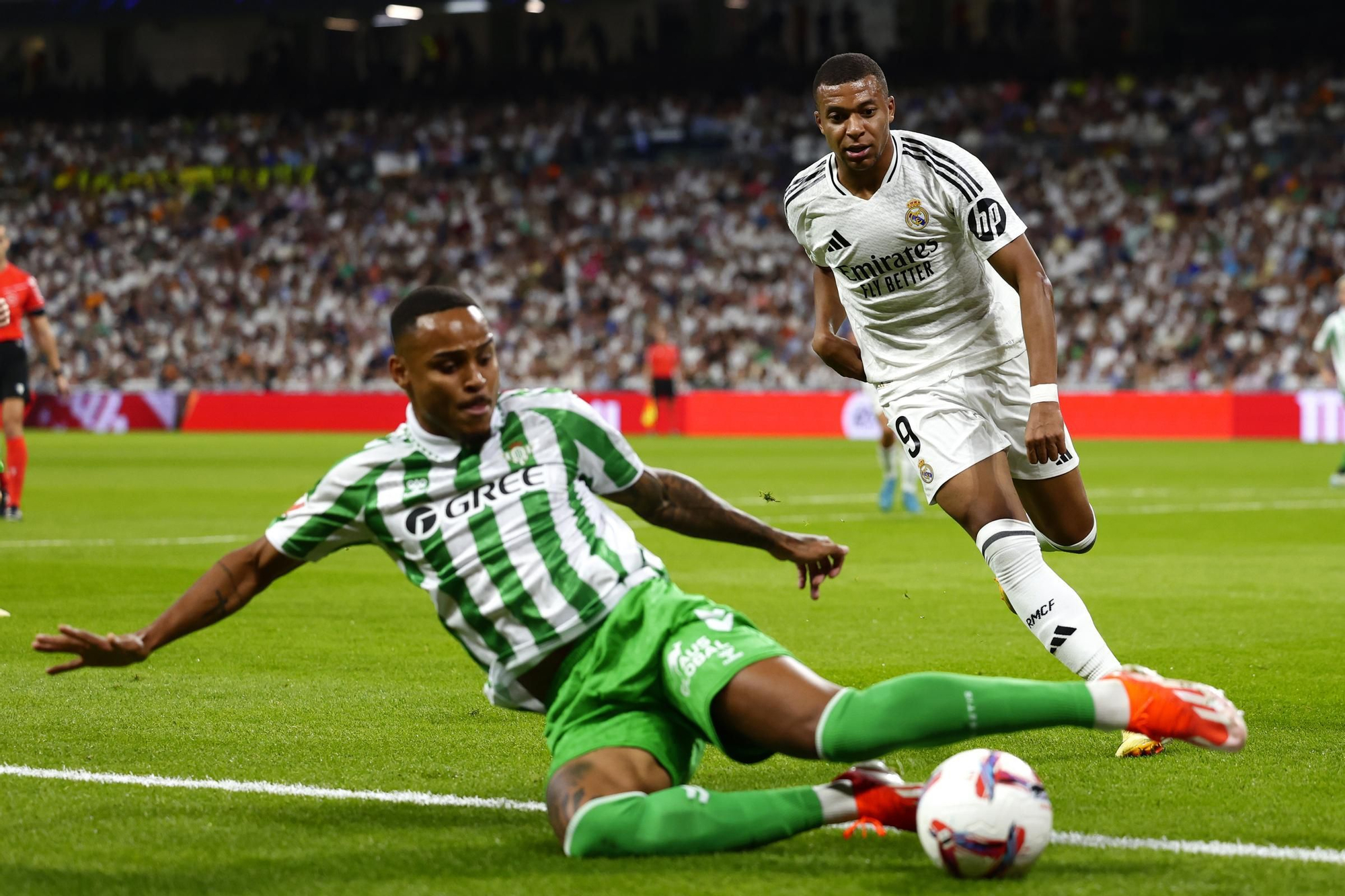 Real Madrid's Kylian Mbappe, right, watches as Betis' Natan clears the ball during the Spanish La Liga soccer match between Real Madrid and Betis at the Santiago Bernabeu stadium in Madrid, Spain, Sunday, Sept. 1, 2024. (AP Photo/Pablo Garcia)