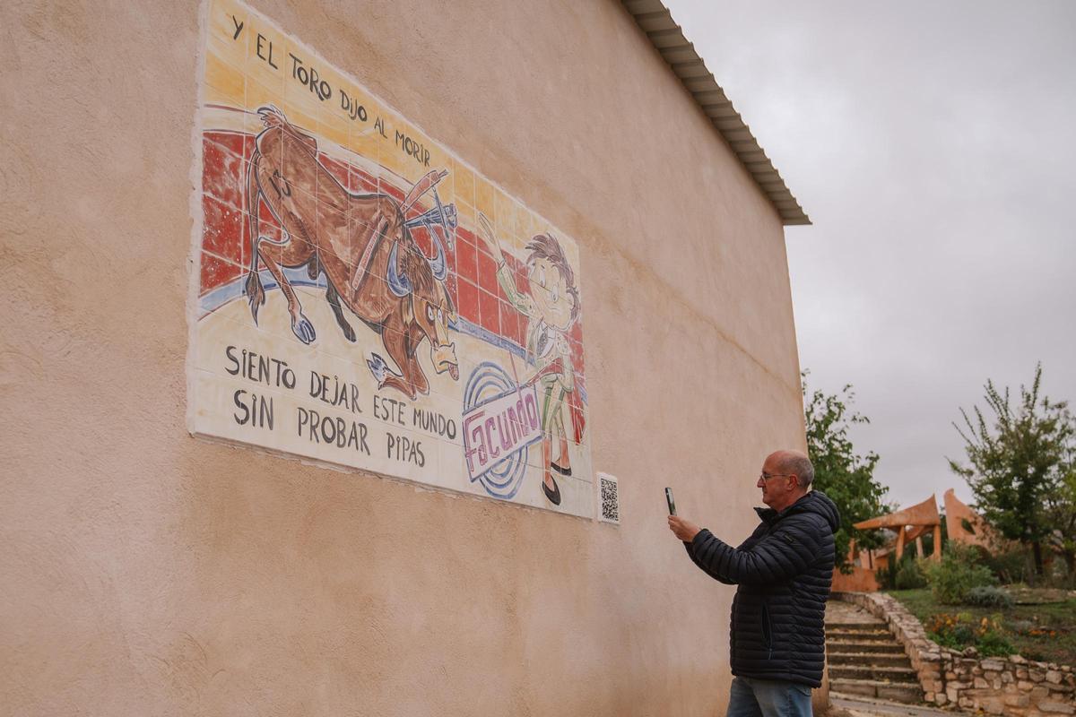 José Luis Regacho, el ex alcalde de Olmeda, escanea el código QR de uno de los anuncios puestos en el pueblo.