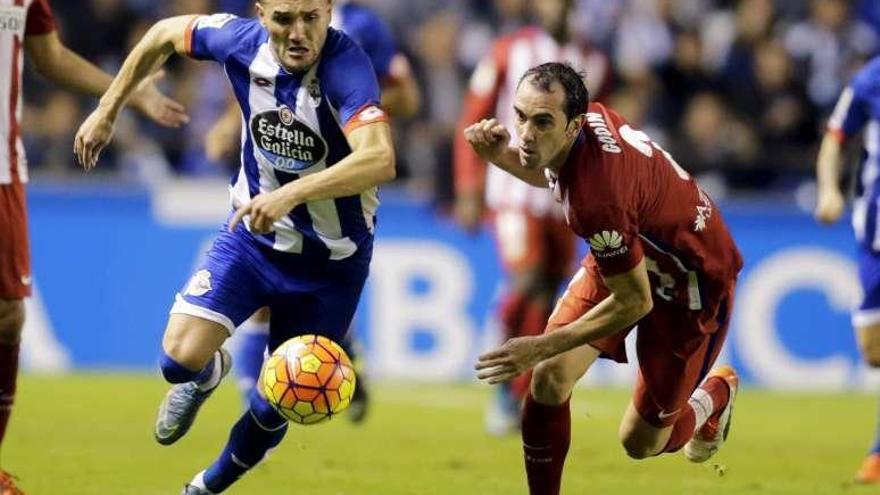 Lucas Pérez, autor del gol del Deportivo, supera el marcaje del rojiblanco Godín.