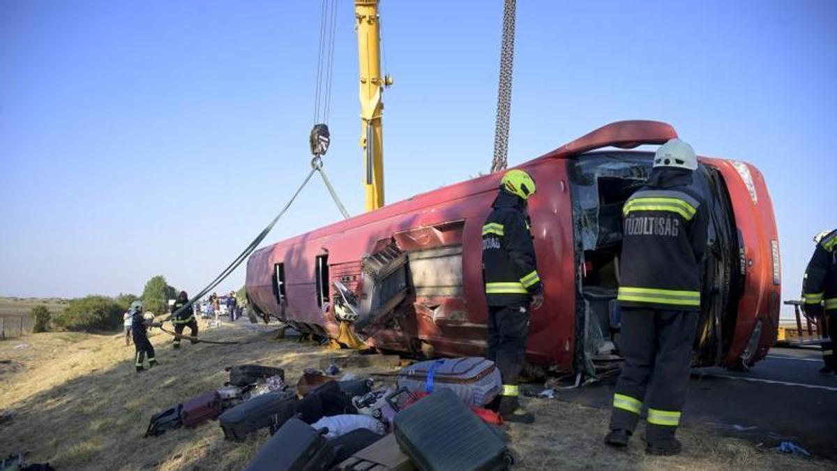 Los bomberos trabajan en el lugar del accidente de un autobús que volcó en Hungría, cerca de la ciudad de Mezokeresztes, el 16 de agosto.