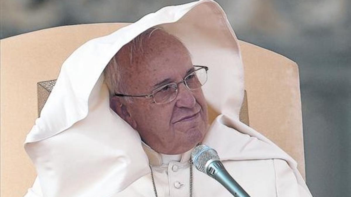 El papa Francisco, ayer, protegido del viento, durante una audiencia general en la plaza de San Pedro.