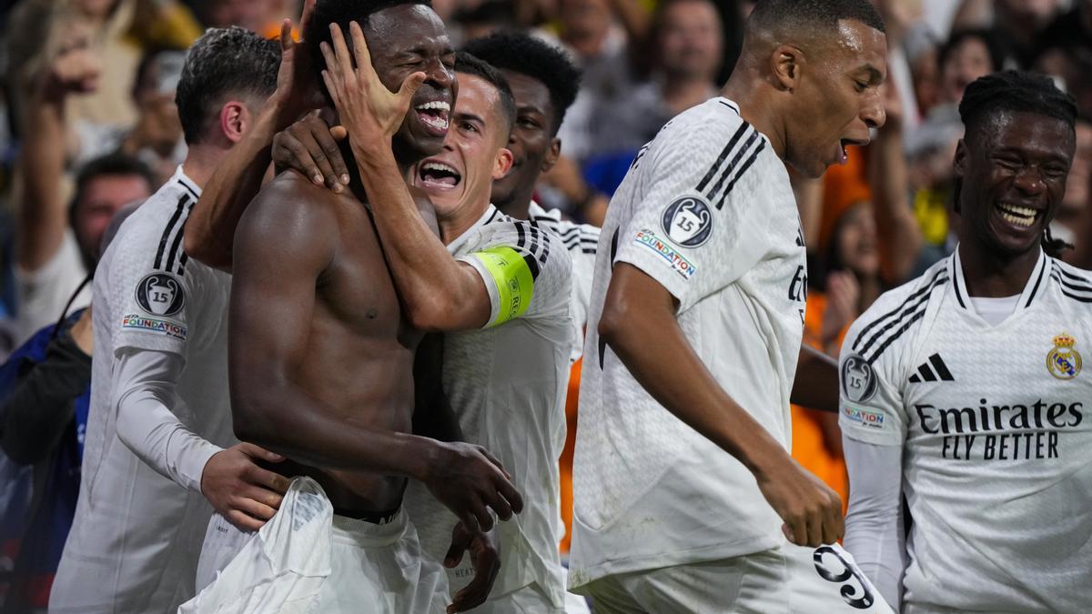 Los jugadores del Real Madrid abrazan a Vinicius tras su triplete frente al Borussia Dortmund.