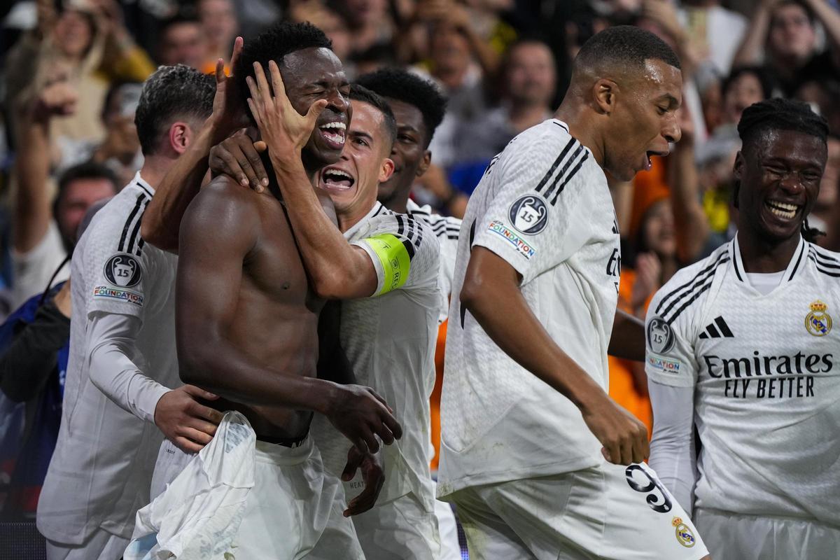 Los jugadores del Real Madrid abrazan a Vinicius tras su triplete frente al Borussia Dortmund.