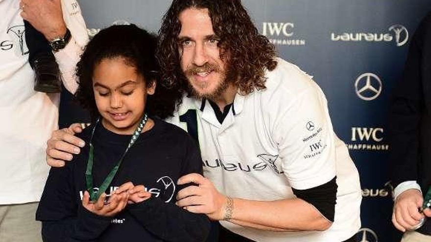 Puyol posa con una niña en Berlín, en vísperas de los premios &quot;Laureus&quot;.