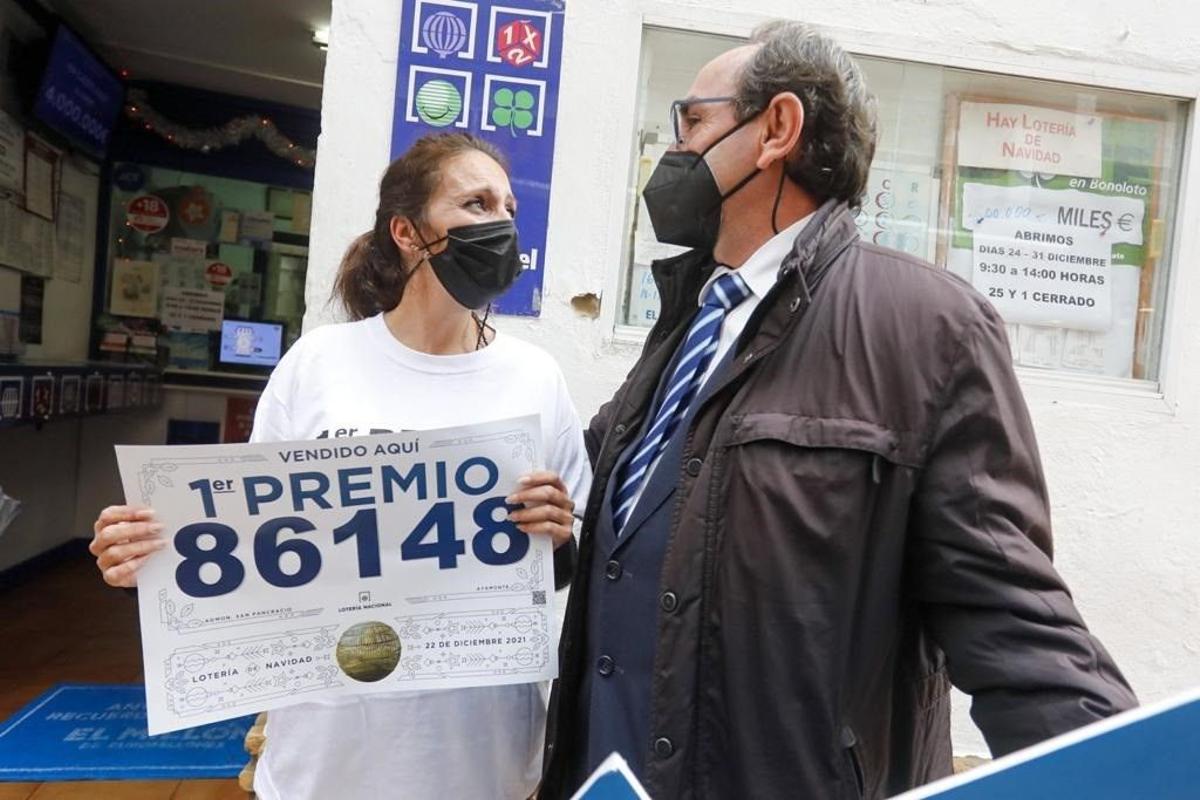 Dos agraciados con el Gordo junto a una administración de Lotería