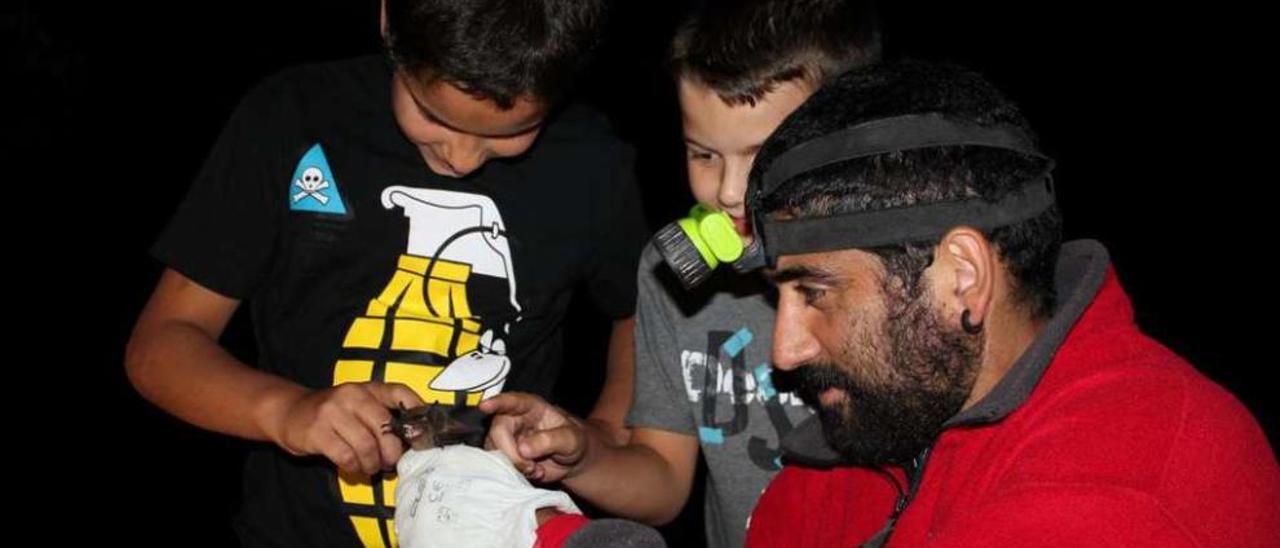 Pardavila enseña a unos niños un ejemplar de murciélado de las huertas en una sesión formativa.