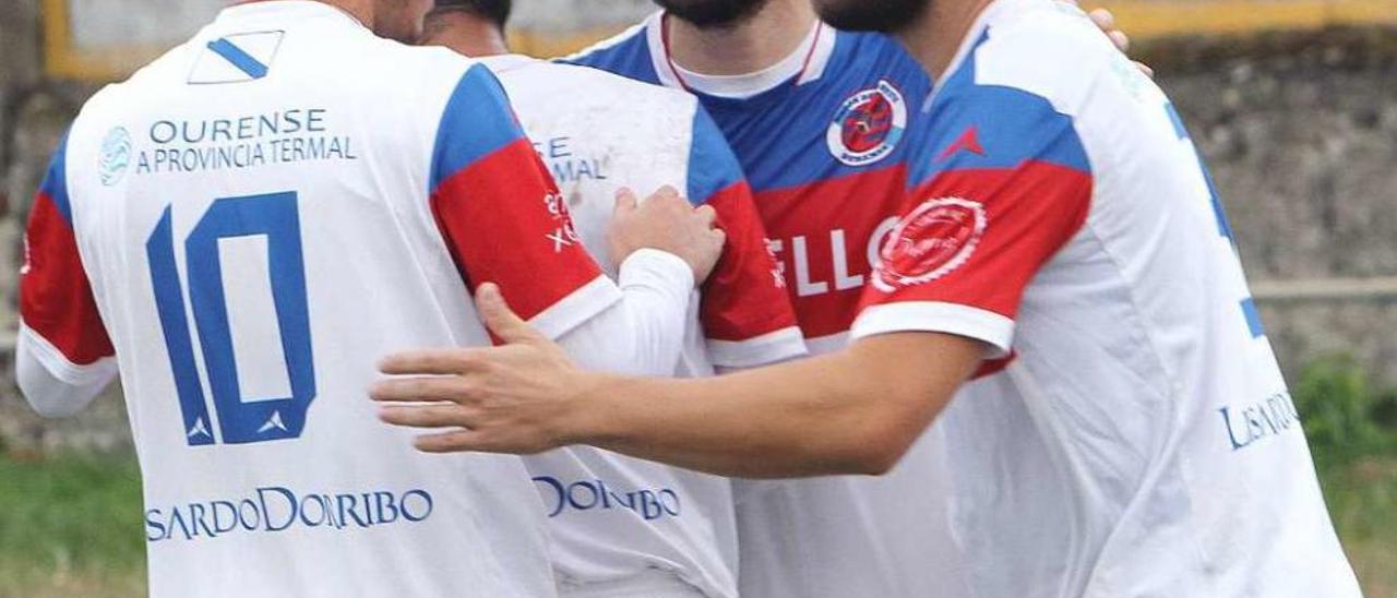 Xurxo se abraza a sus compañeros tras un gol de la UD Ourense en Trives. // Iñaki Osorio