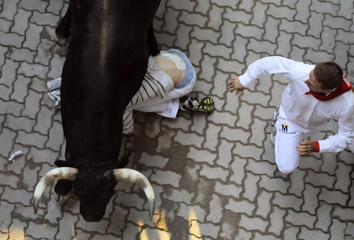 Un corredor es protegeix d’un toro.