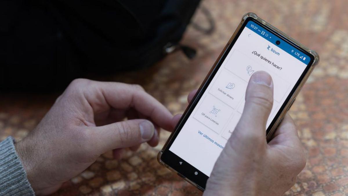 Un hombre realiza un bízum desde su teléfono móvil. | EUROPA PRESS (ARCHIVO)