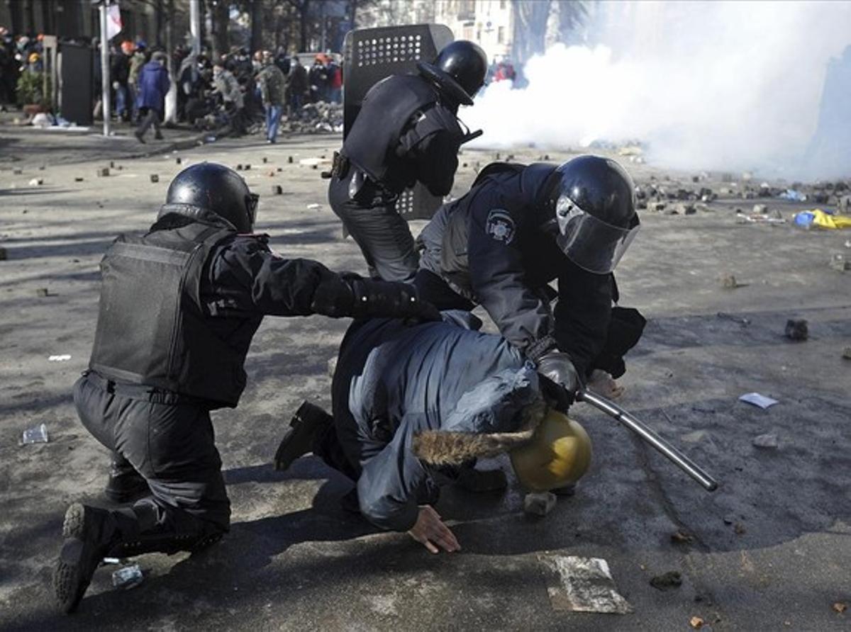 Tres policías detienen a uno de los manifestantes, en Kiev.