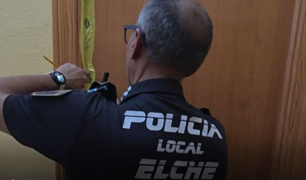 Un policía, clausurando la vivienda